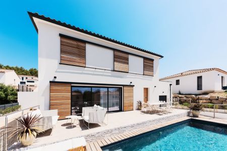 Schiebeläden in Holzoptik mit schwarzen Rahmen an Fenstern und Terrassentür eines modernen Wohnhauses.