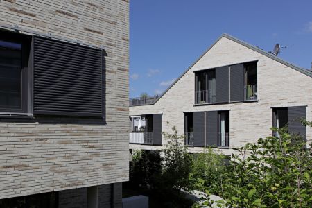 schwarze Schiebeläden aus Aluminium an moderner Hausfassade
